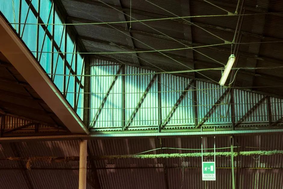 View of an industrial warehouse ceiling with metal beams and skylights.